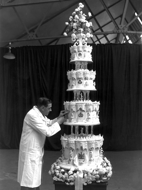 The finishing touches are put on Queen Elizabeth II's towering wedding cake.