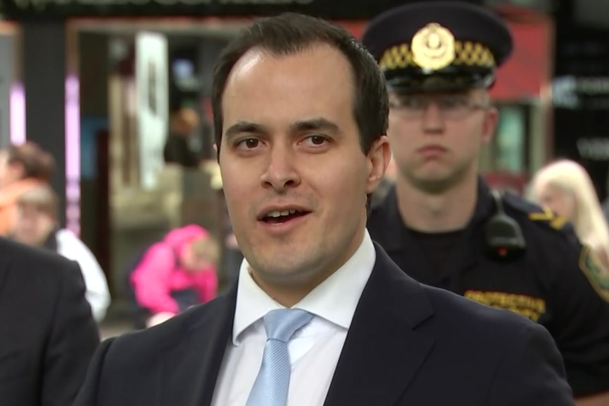 A man with black hair wearing a suit and tie