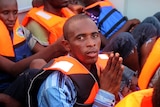 Young African man prays after being rescued by the Italian navy
