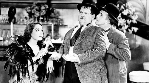 Black and white still of Lupe Vélez and comedy duo Laurel & Hardy in 1934 film Hollywood Party.