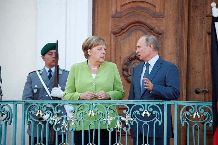 Putin and Merkel chat while standing on balcony