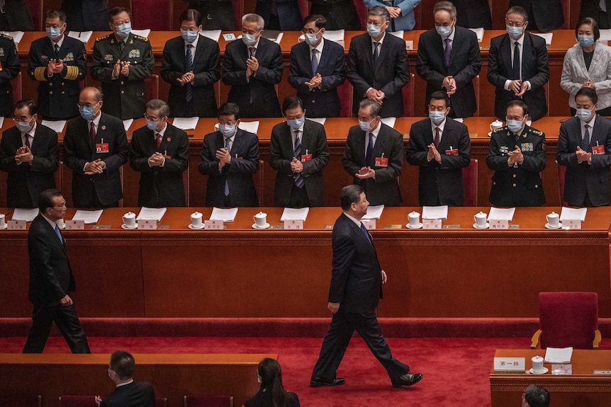 President Xi Jinping is applauded by standing members of the Communist Party as he strolls in front