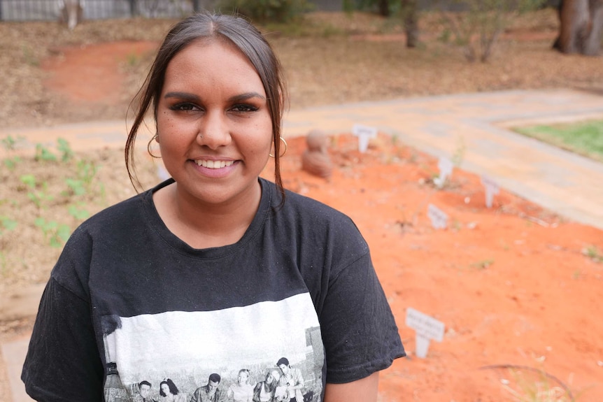 A young Aboriginal woman stares down the camera