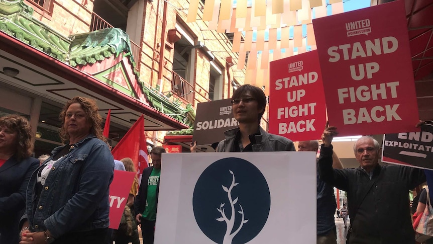 Protesters hold placards in Chinatown in Adelaide's CBD.