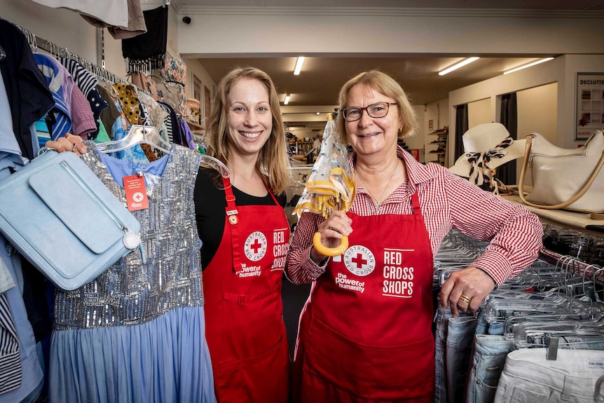 Two women volunteers in a Red Cross  charity shop.