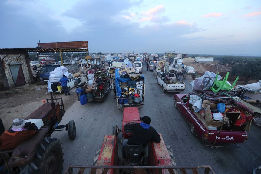 Refugees load tractors and trucks with their belongings