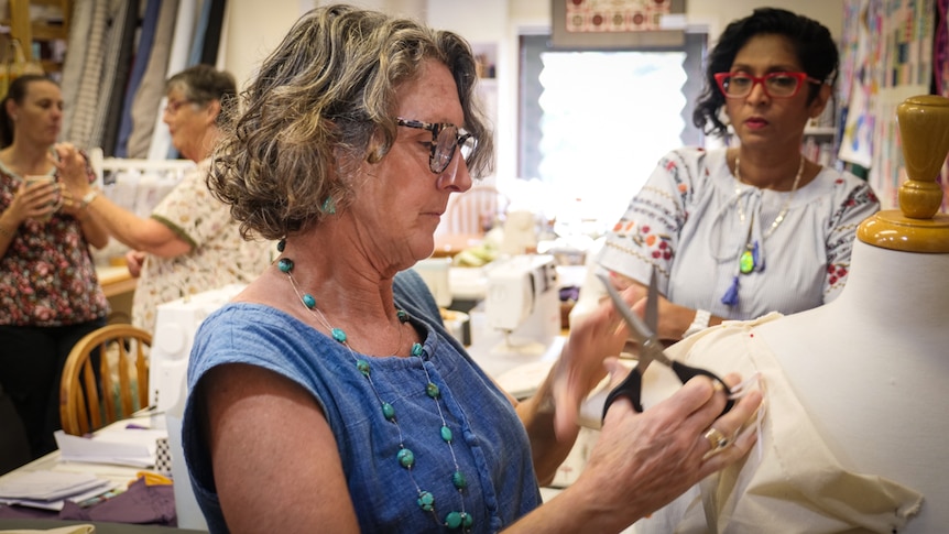 A group of participants watch and learn how to make a toile