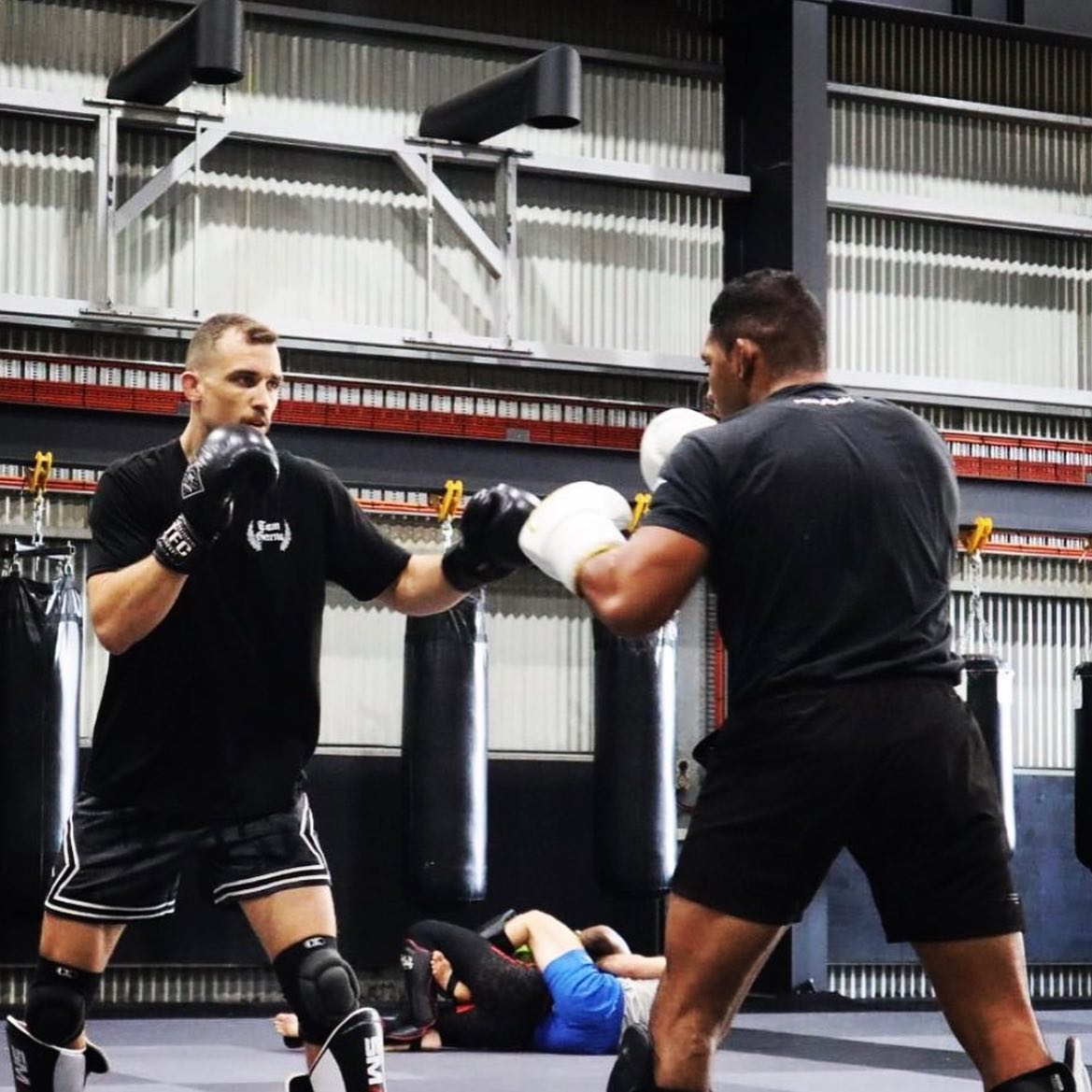 Ben Johnston s'entraîne avec un étudiant dans une salle d'arts martiaux mixtes.