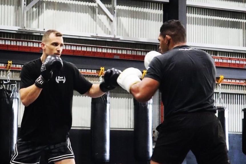Ben Johnston sparring with a student in a mixed-martial-arts gym.