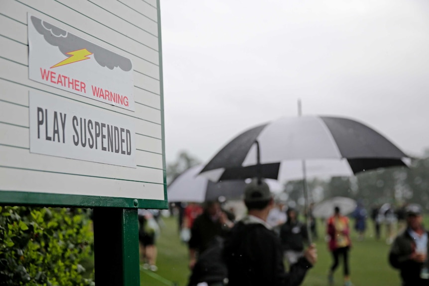 A sign showing play is suspended due to weather during the par-three competition at the Masters.