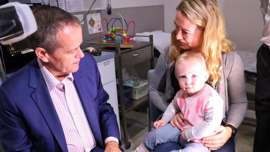 Bill Shorten meets with a woman and her child inside a medical centre in Sydney.