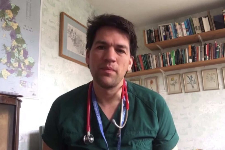 Dr Alex Armitage in green top with stethoscope around his neck in an office.