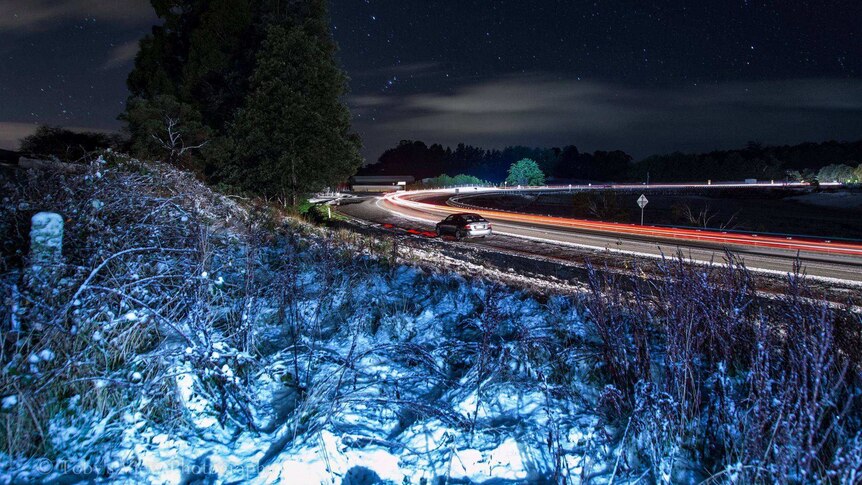 Timelapse photo of icy conditions on road bend at night.