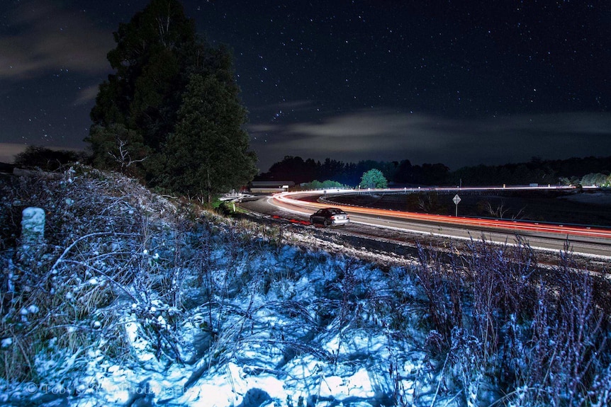 Timelapse photo of icy conditions on road bend at night.
