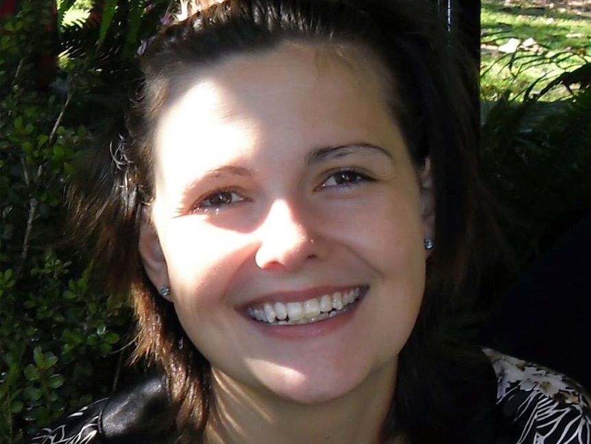 A young woman with short, dark hair smiling broadly.