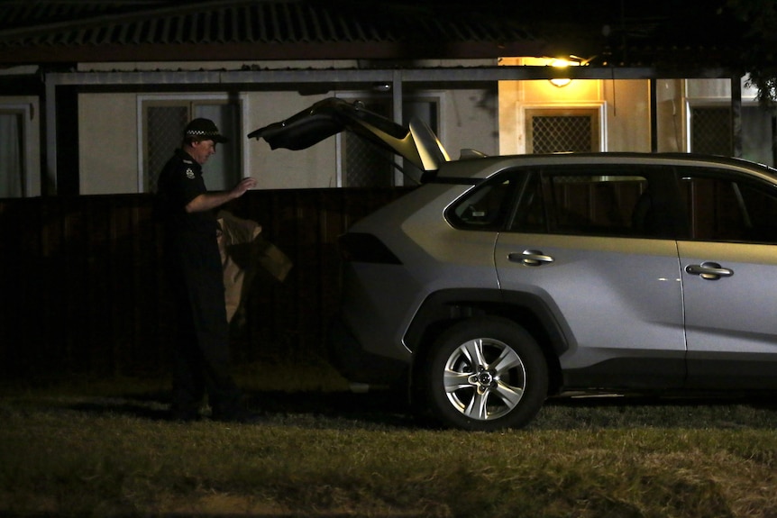 A forensic investigator places brown paper bags in the back of his car outside Cleo Smith's family home in South Carnarvon. 