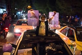 A girl holds posters of Iranian President Hassan Rouhani.