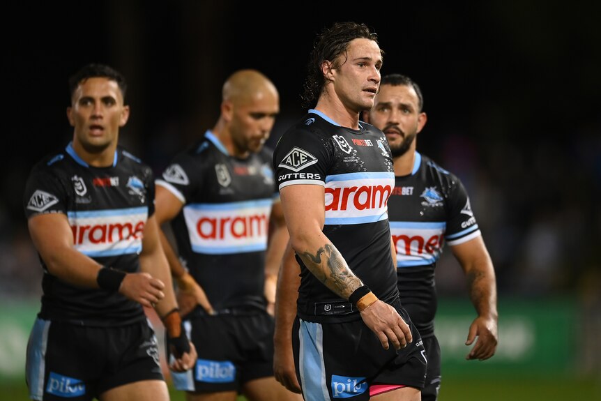 Nicho Hynes leads the Cronulla Sharks off the field in an NRL game.
