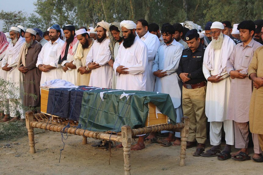 Local residents offer the funeral prayer of an intelligence officer in Charsadda, Pakistan, Monday, Oct. 24, 2016.