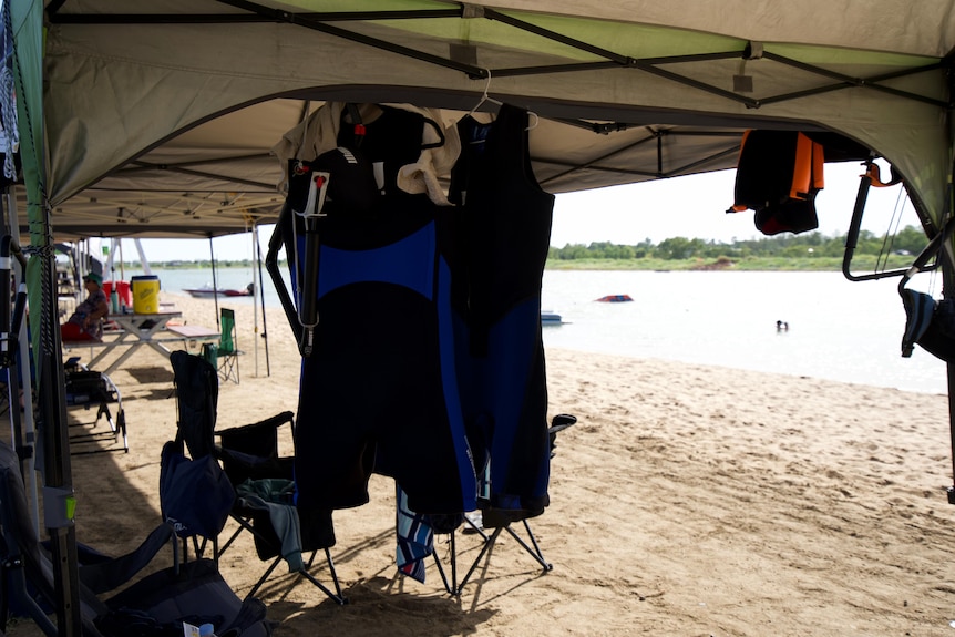 Swim suits hanging in tent near sand