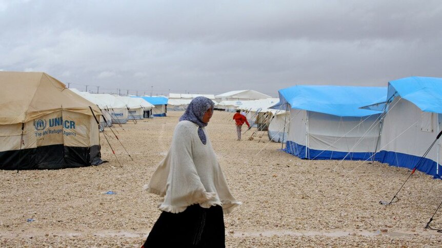 Woman walks through the Zaatari refugee camp