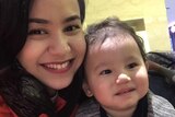Nadila Wumaier smiles at the camera beside her two-year-old son Lutfy in this selfie photo.