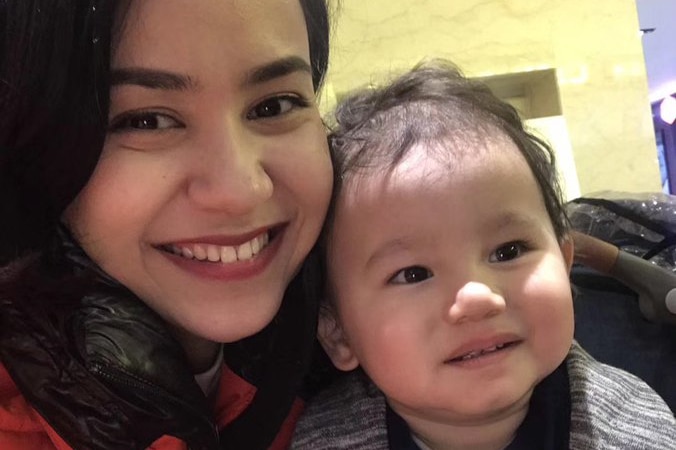 Nadila Wumaier smiles at the camera beside her two-year-old son Lutfy in this selfie photo.