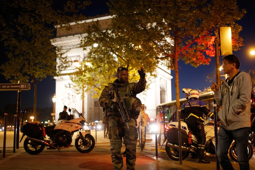 An armed soldier secures a Champs Elysee side street in Paris following a fatal shooting