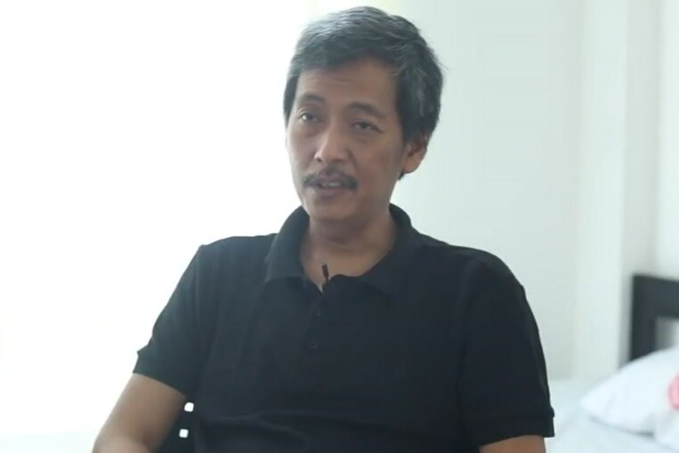 An Indonesian man in a polo shirt speaks.