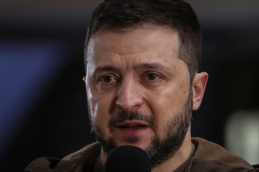 Close up of teary man speaking into microphone.