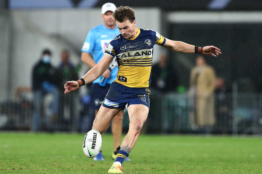 A Parramatta NRL player drop kicks the ball for the winning field goal against Canberra.