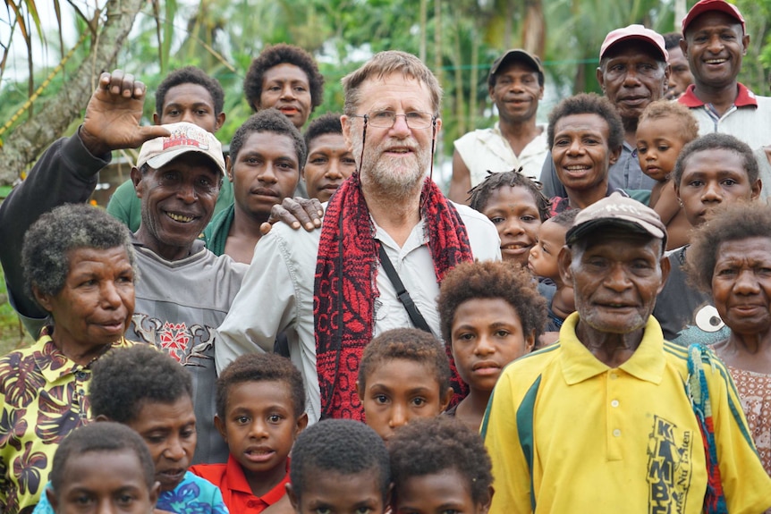 Geographer Bryant Allen surrounded by Tumam villagers