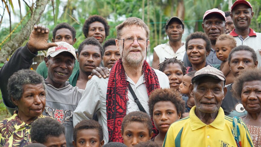 Geographer Bryant Allen surrounded by Tumam villagers