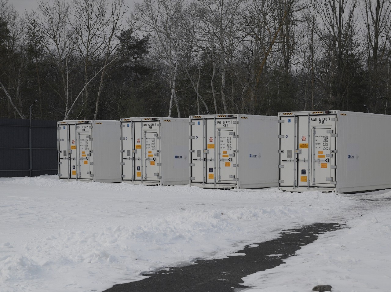 Several large containers placed outdoors. Snow is visible around them.