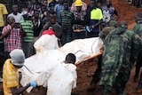 Rescue workers carry a body on a stretcher.