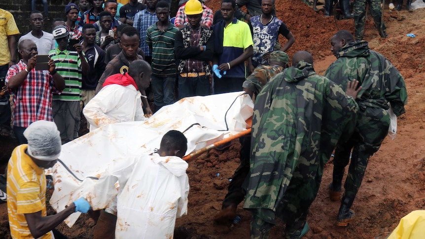 Rescue workers carry a body on a stretcher.