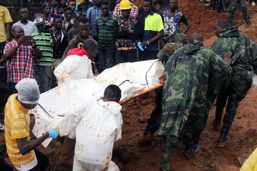 Rescue workers carry a body on a stretcher.