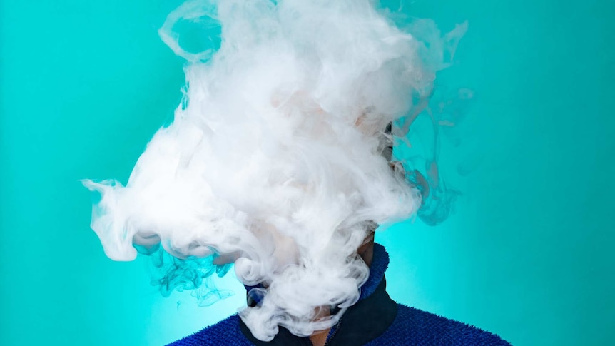 A huge cloud of smoke covers a man's face