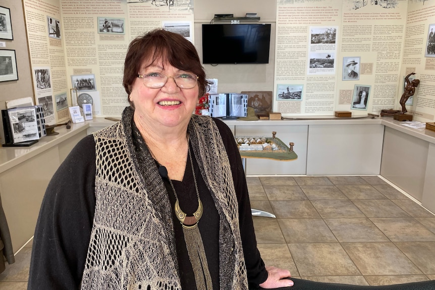 A woman standing in front of a history display. 