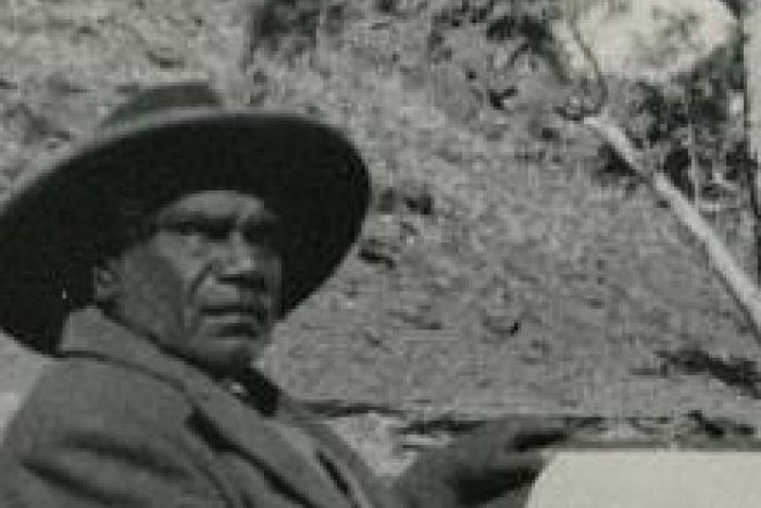 Black and white photo of Albert Namatjira sitting in the backcountry