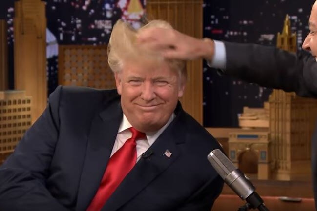 Donald Trump smiles as Jimmy Fallon messes with his hair