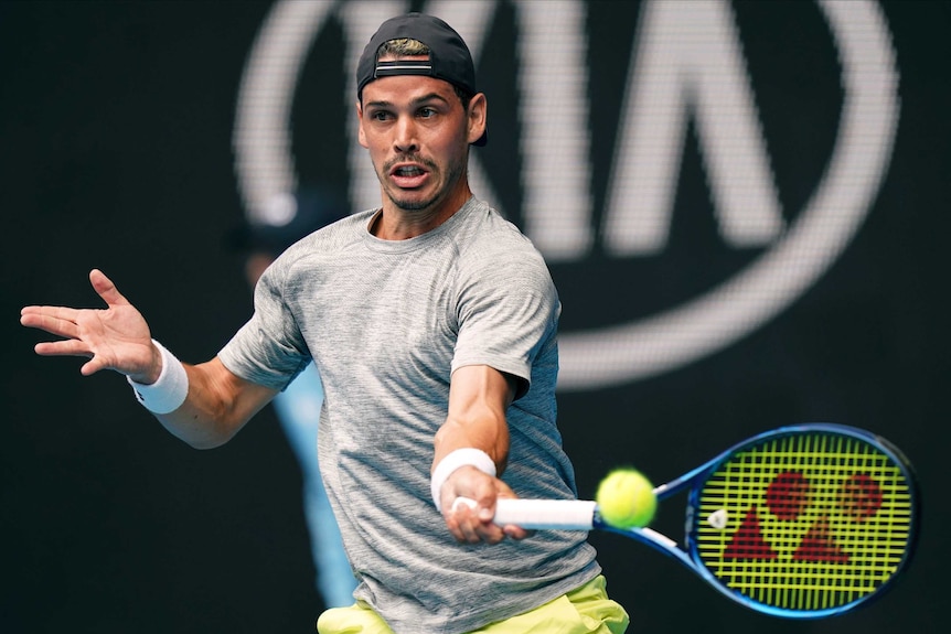 A male tennis player stretches to play a forehand return at the Australian Open.