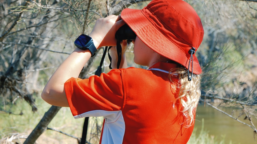 A student looking through binoculars