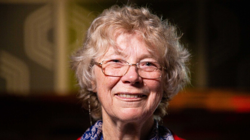 An older woman smiling happily as she looks at the camera