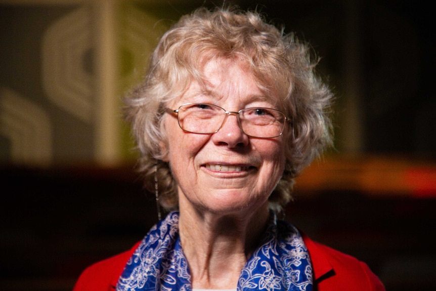 An older woman smiling happily as she looks at the camera