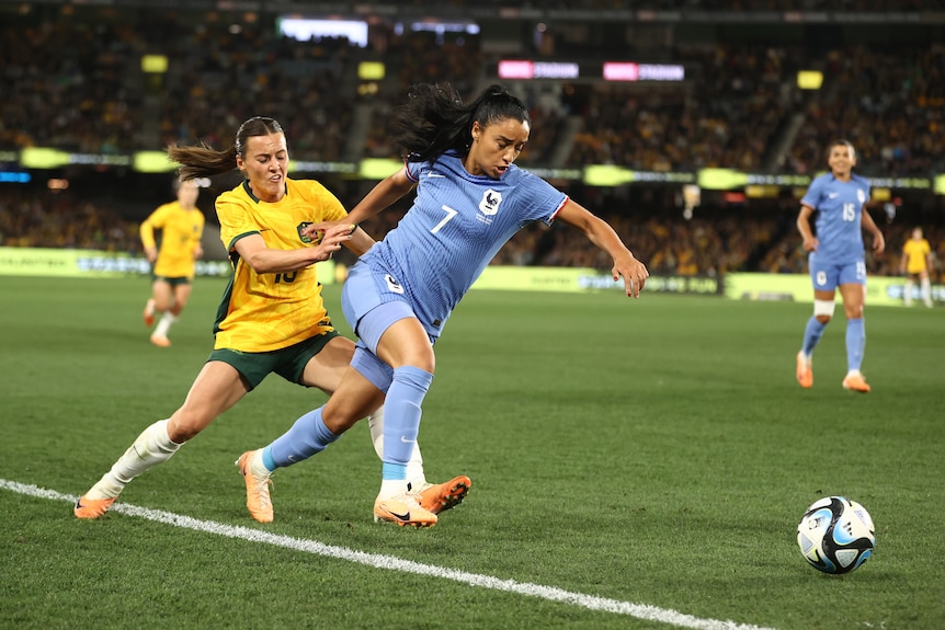 Australia's Hayley Raso tussles with France's Sakina Karchaoui during a football game.