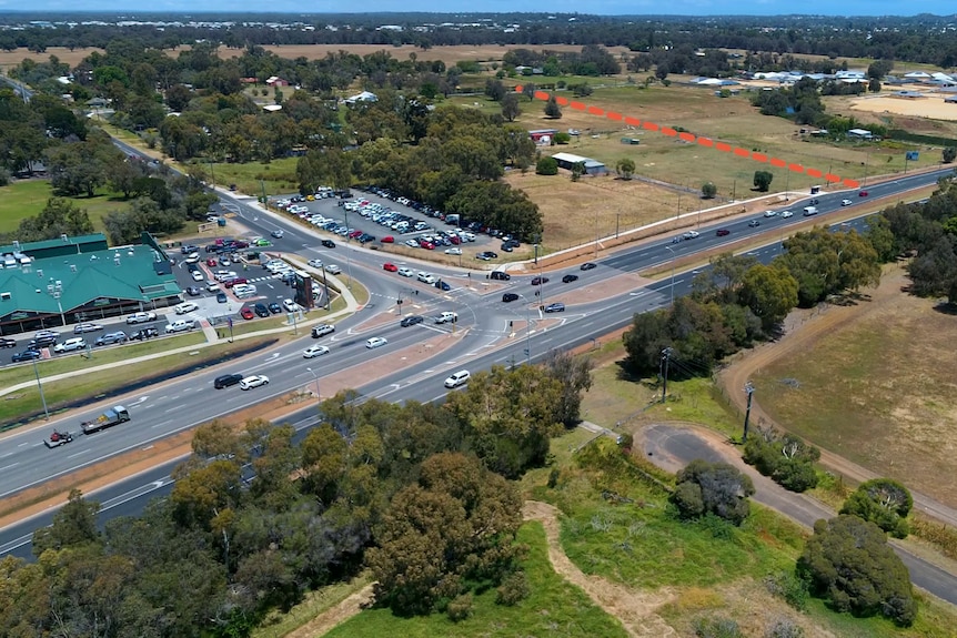 An aerial photo of a highway intersection with an orange dotted line marked