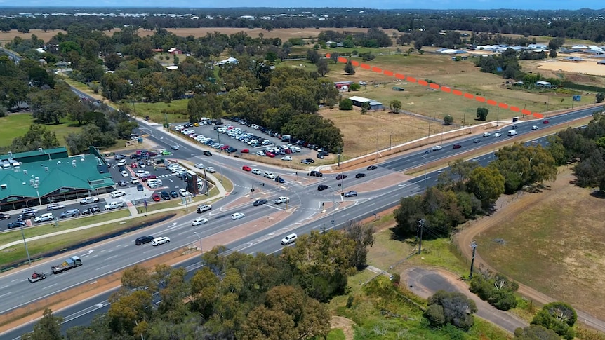 An aerial photo of a highway intersection with an orange dotted line marked