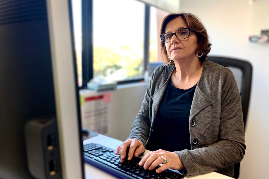 United Workers Union president Jo Schofield types at her computer in an office