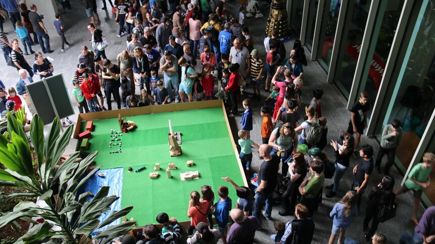 Crowds gather around an exhibition at Robotronica
